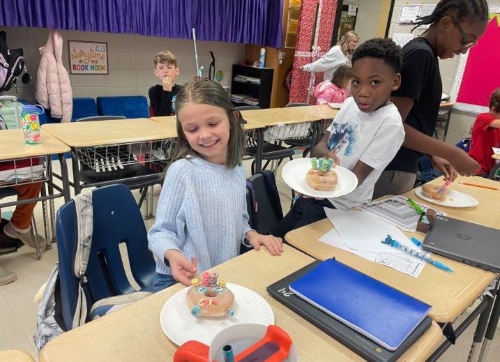 4th grade math is fun with donut turkeys!  picture of kids posing with their donut turkeys 