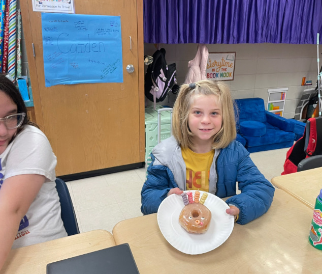 4th grade math is fun with donut turkeys!  picture of kids posing with their donut turkeys 