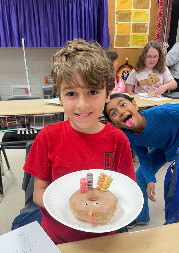 4th grade math is fun with donut turkeys!  picture of kids posing with their donut turkeys 