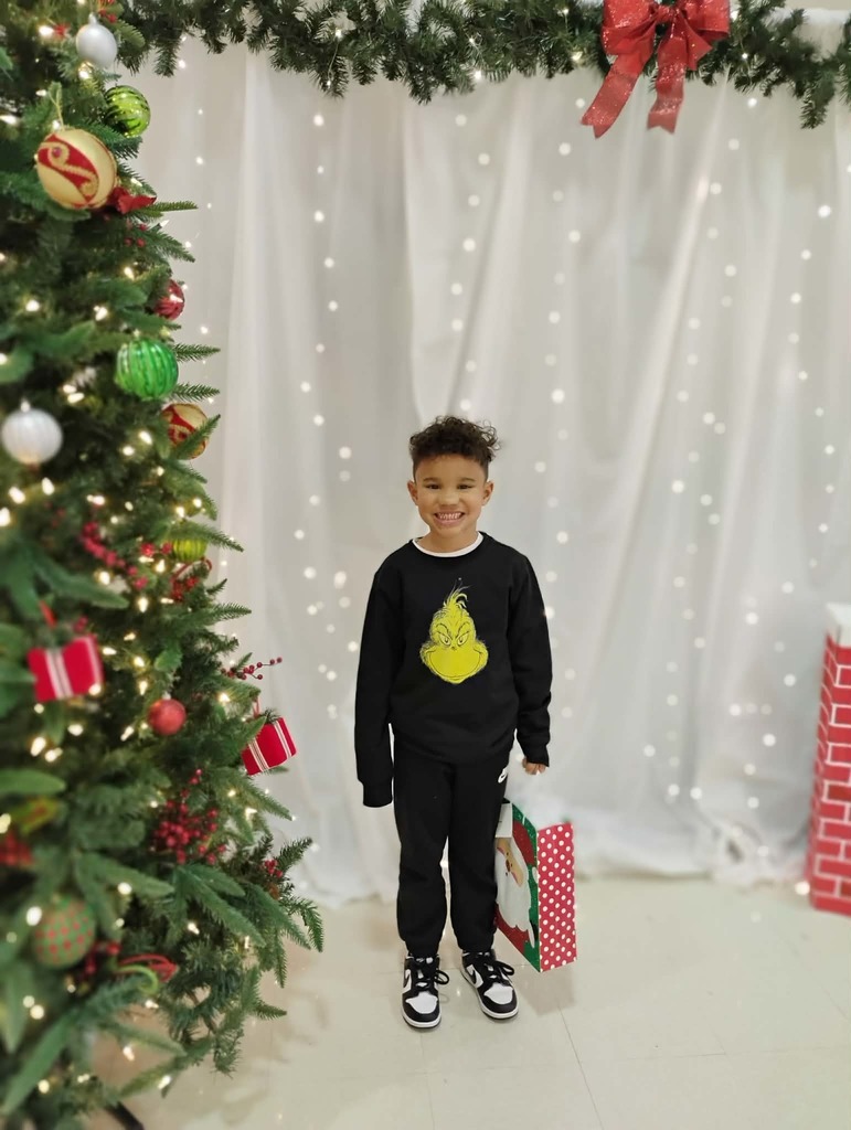 Julian Ashmore won a prize at reading night. Picture of him posing with her prize at the cute backdrop.