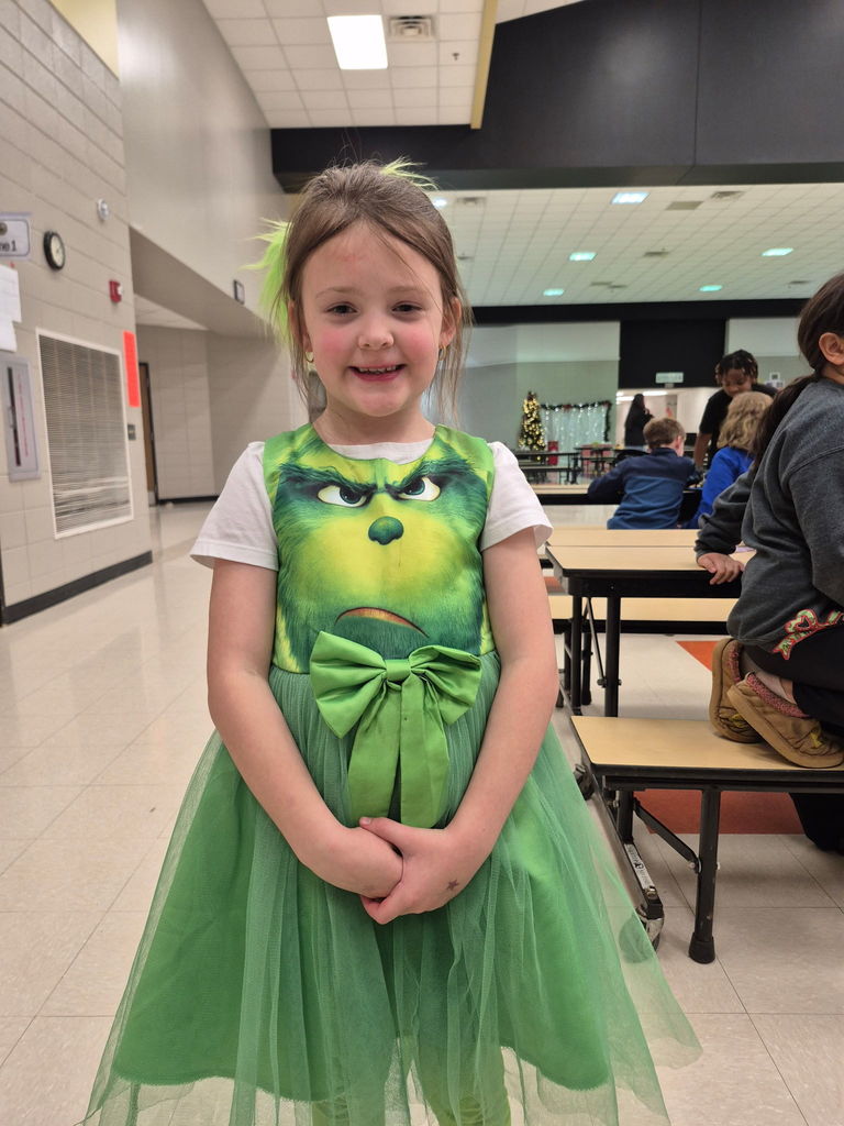A student posing for the camera in her grinch attire. 