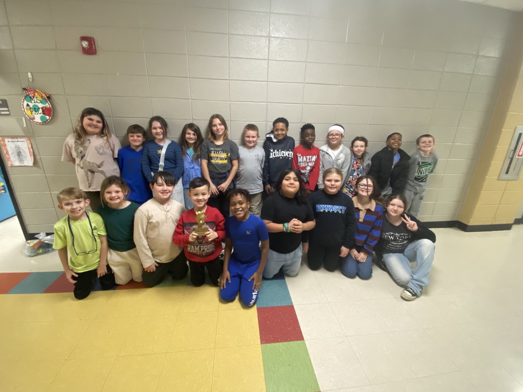 Picture is of a 4th grade class posing with the GOAT trophy. 