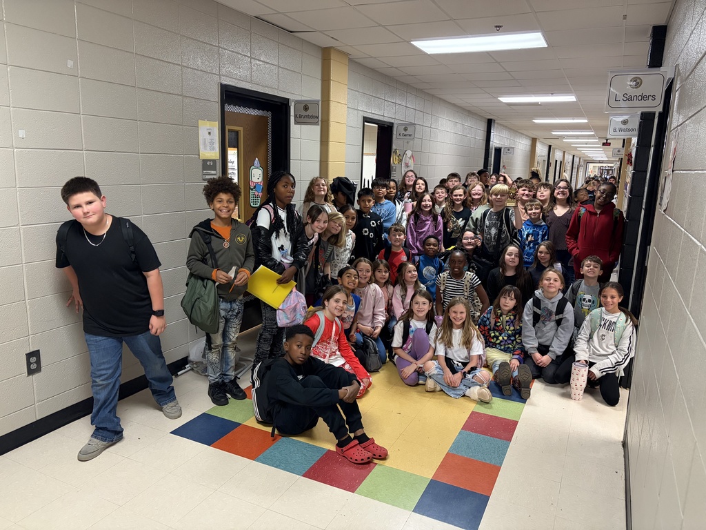 Picture is of two 4th grade classes posing with the GOAT trophy.