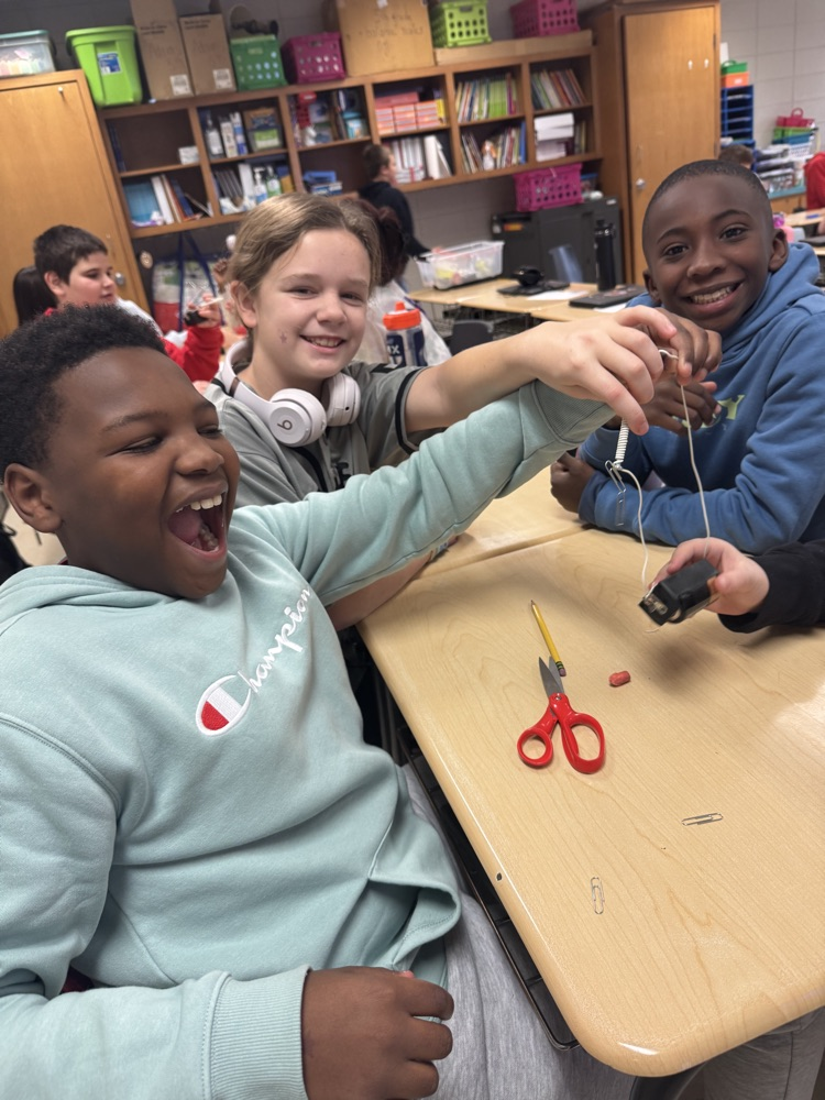 🧲 Hands-on science in action! Today, students built their very own electromagnets and discovered the amazing connection between electricity and magnetism! picture is of students working in small groups with magnets 