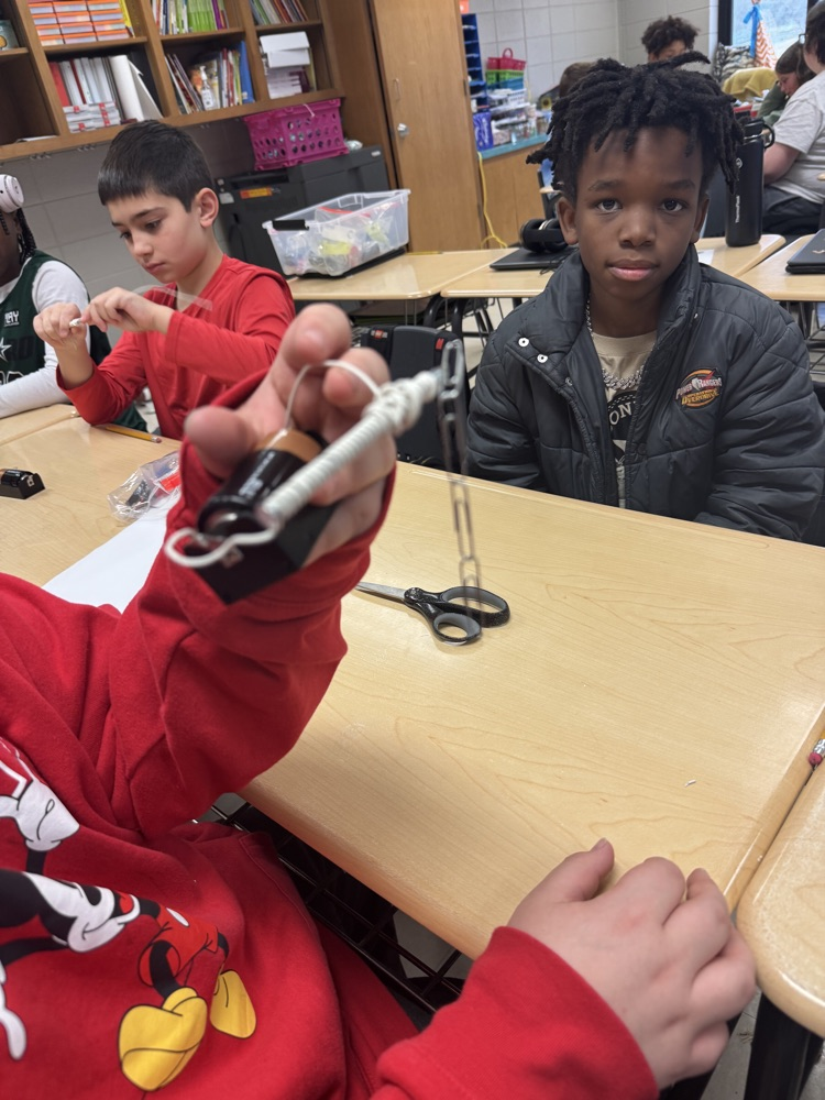 🧲 Hands-on science in action! Today, students built their very own electromagnets and discovered the amazing connection between electricity and magnetism! picture is of students working in small groups with magnets 