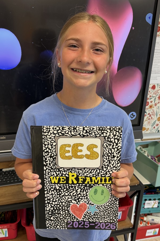 Student holding a yearbook design.