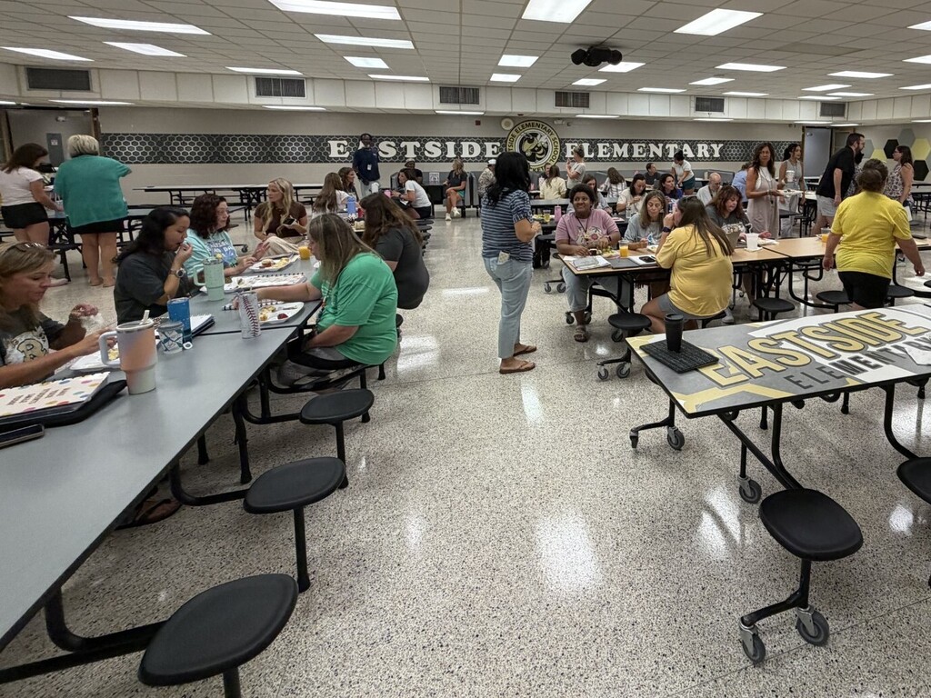 Teachers and staff eating breakfast in the school cafeteria