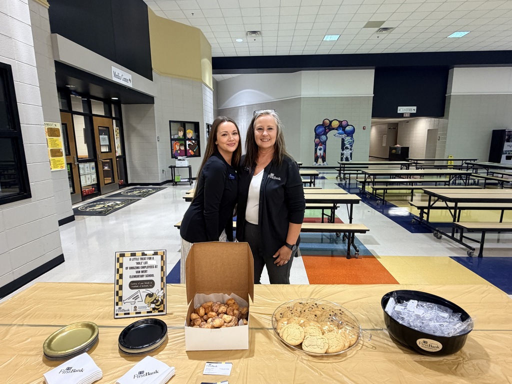 Two workers at FirstBank posing in front of the snacks they brought today. 