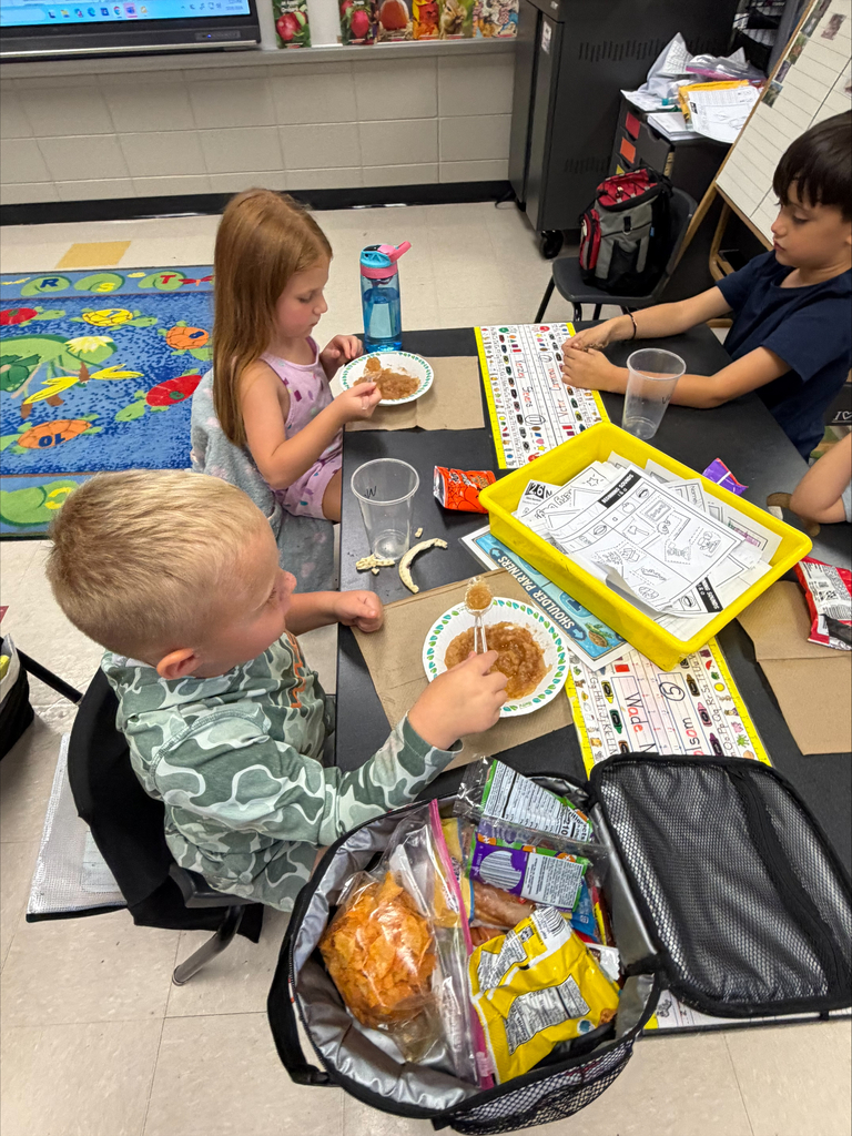 Students eating apple sauce and apple created items in school. 