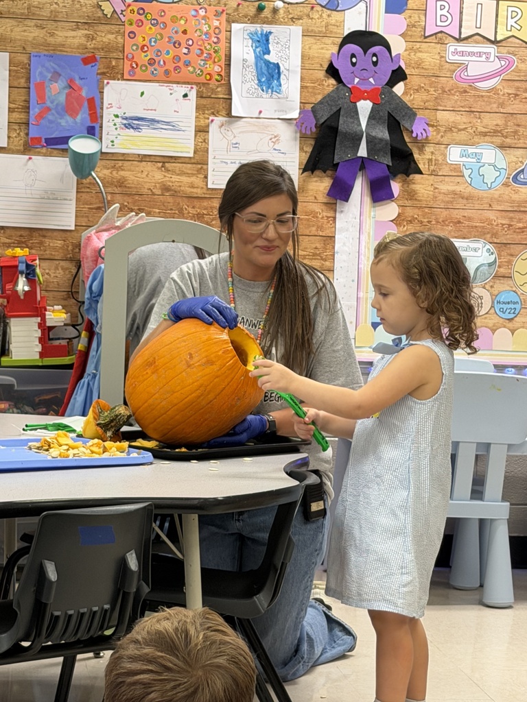 Mrs. Carver's students pulling seeds out of a pumpkin. 