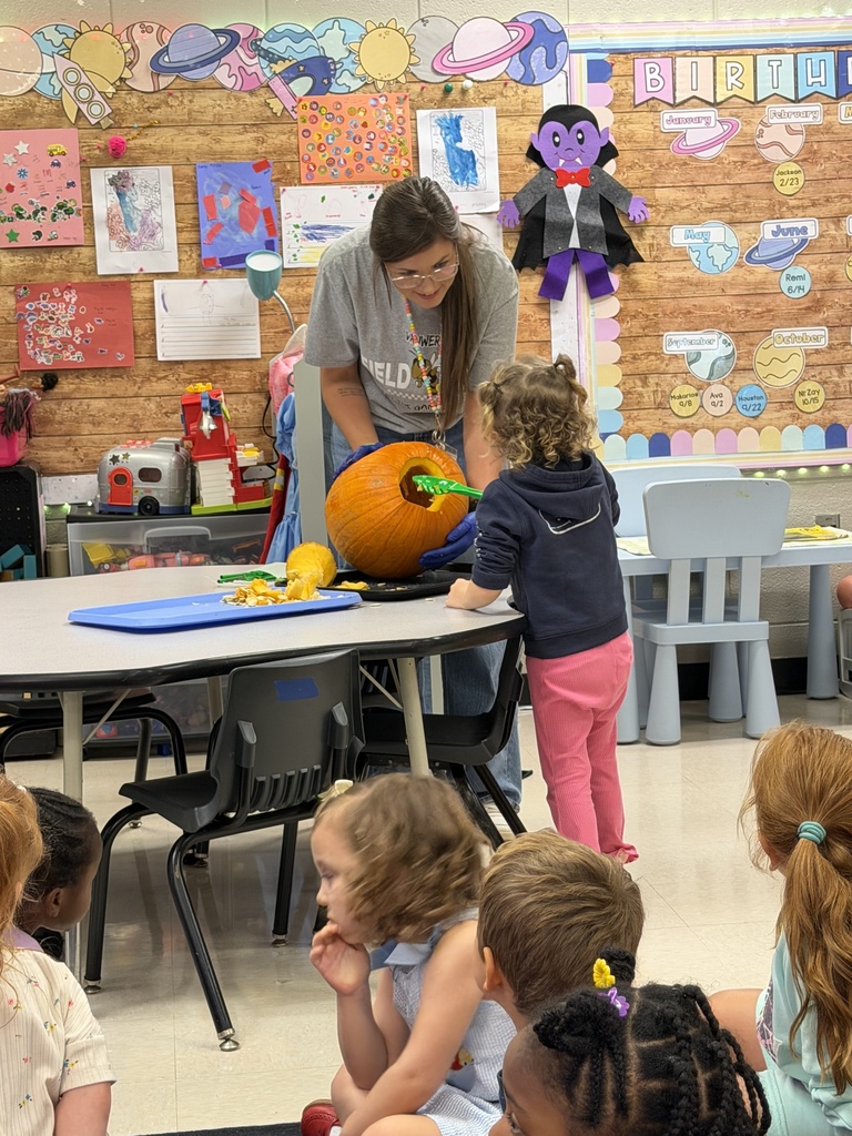 Mrs. Carver's students pulling seeds out of a pumpkin. 