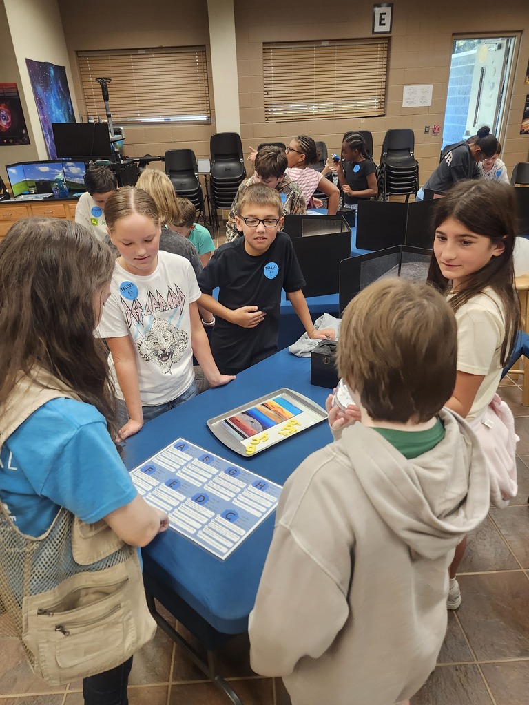 Picture of 4th grade students learning hands on activities on a field trip. Pic of small group of kids working. 