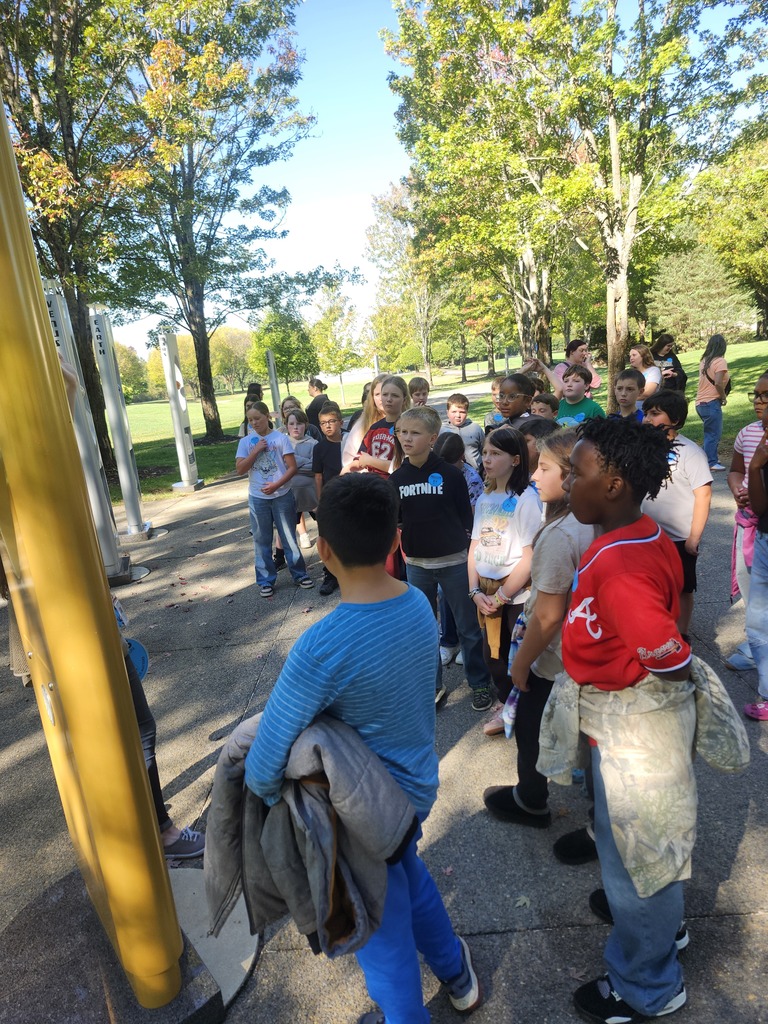 Picture of 4th grade students learning hands on activities on a field trip outside. 