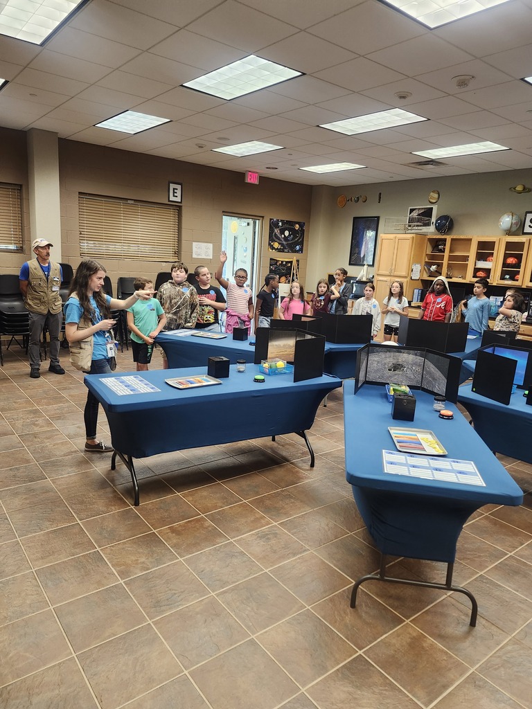 Picture of 4th grade students learning hands on activities on a field trip. Whole class picture during a demonstration with handson activity. 