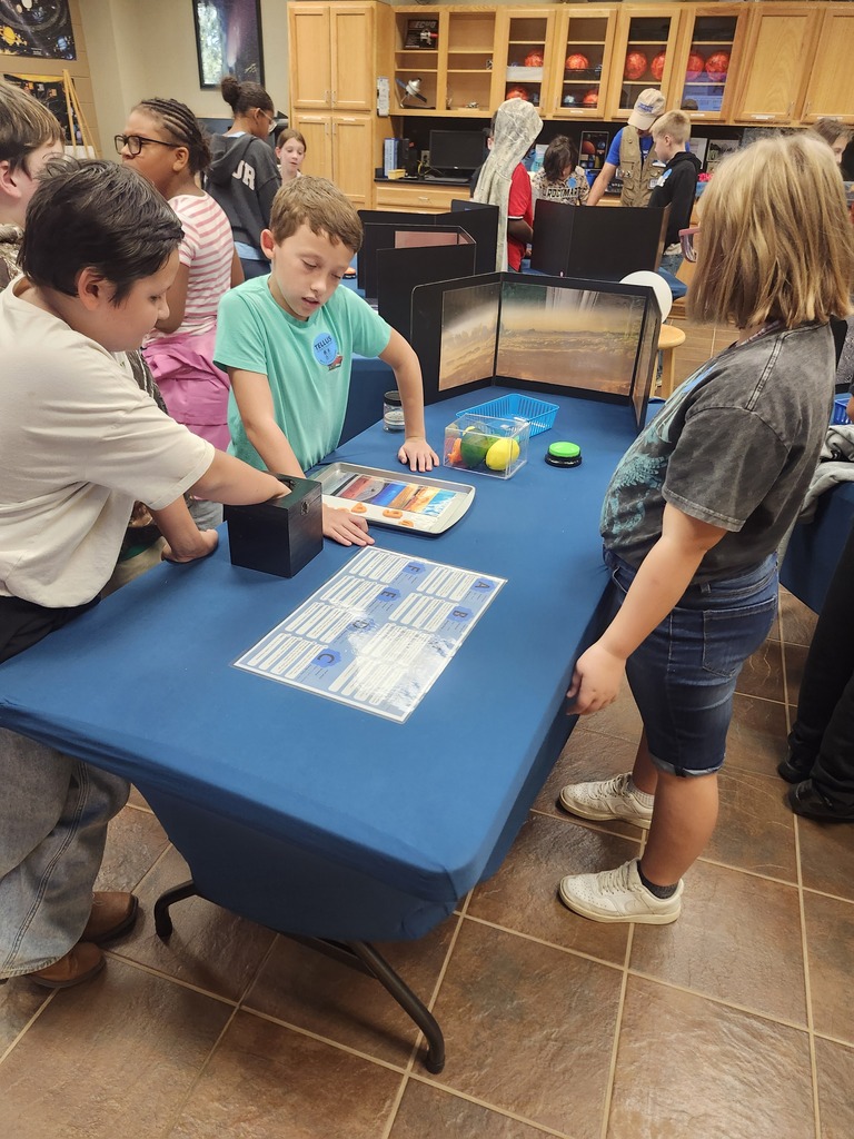Picture of 4th grade students learning hands on activities on a field trip. 