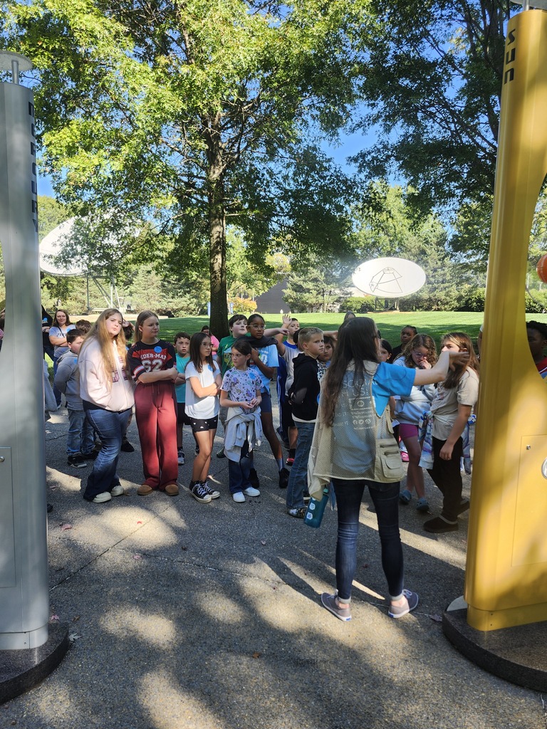 Picture of 4th grade students learning hands on activities on a field trip outside. 