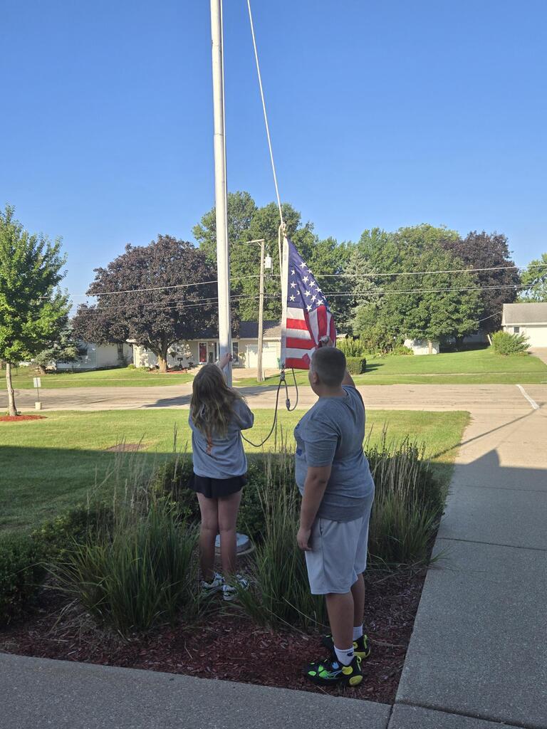 5th grade students raising our American flag to half-staff in honor of September 11th
