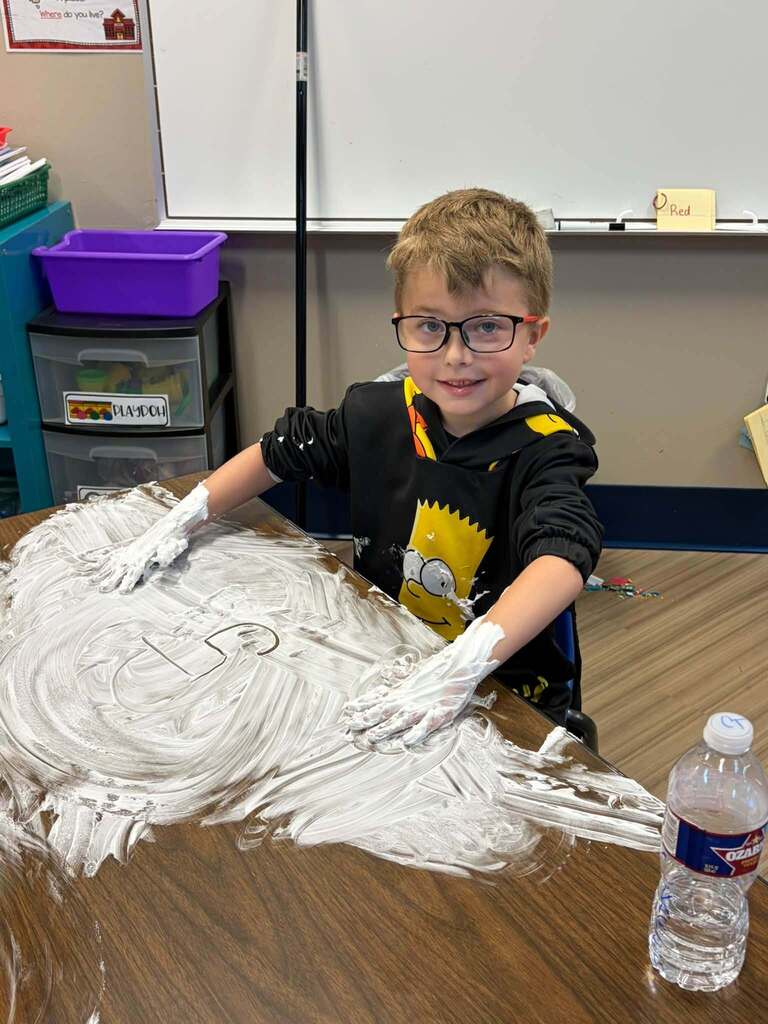 Child playing in shaving cream.