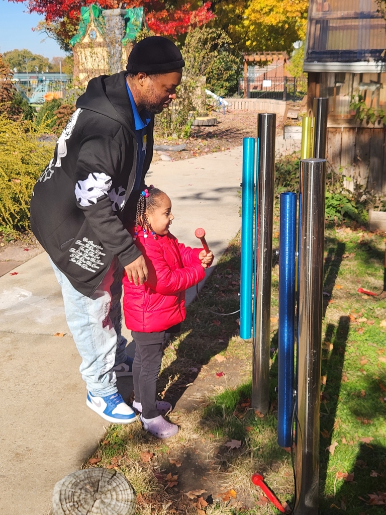 A girl and her dad playing musical instruments 