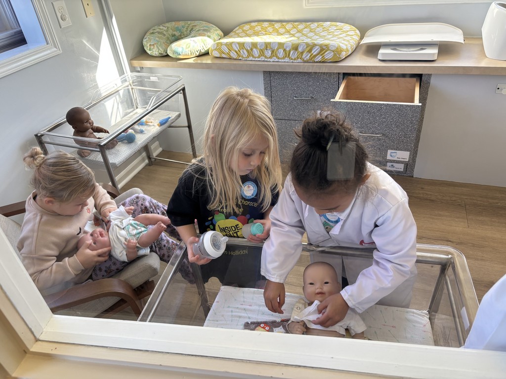 Three girls take care of baby dolls