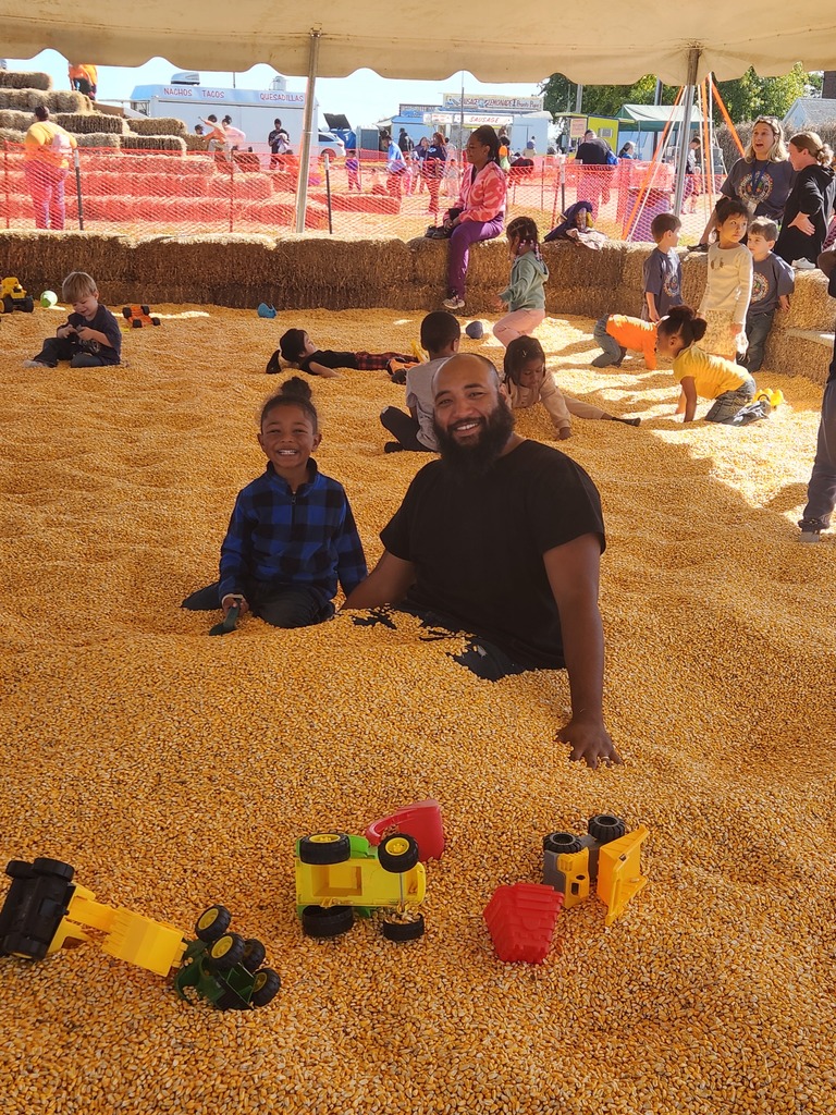 A boy and his dad in a giant pit of corn