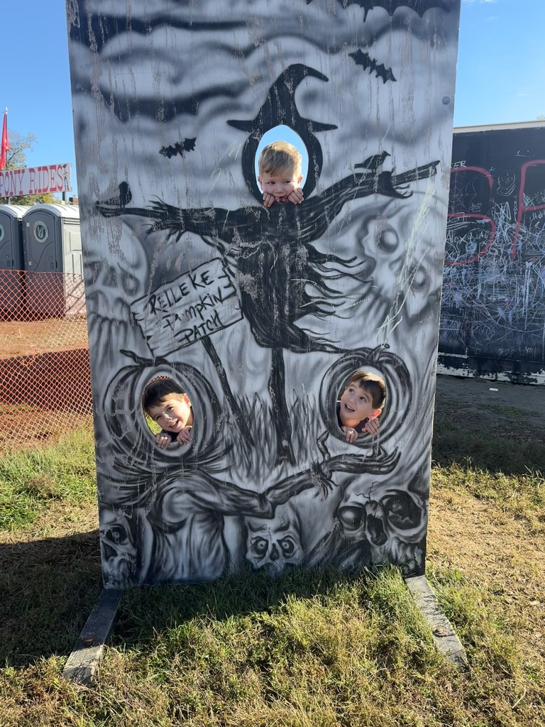 Three boys sticking their faces through a spooky photo spot