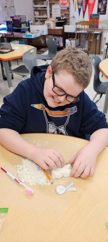 Students carving a medal