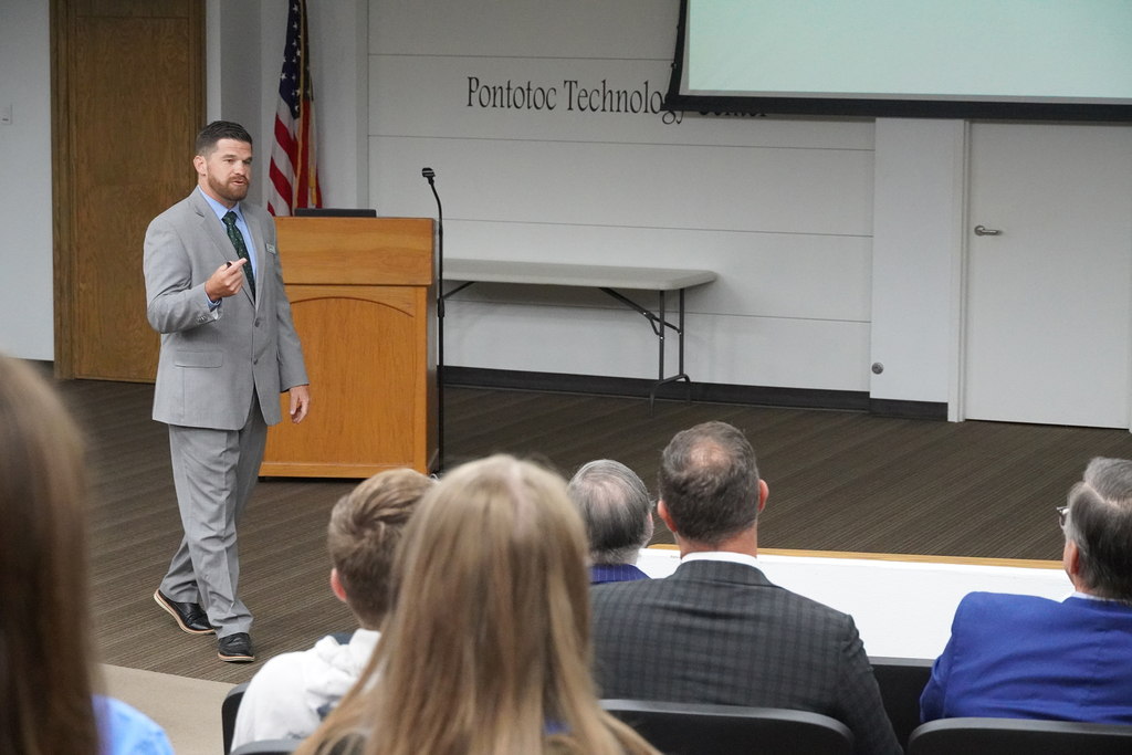 Man presenting to group in a seminar center.