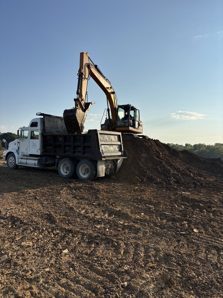 Heavy equipment loading dirt into a dump truck