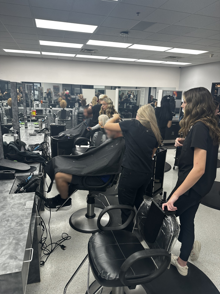 Cosmetology students performing mens haircuts.
