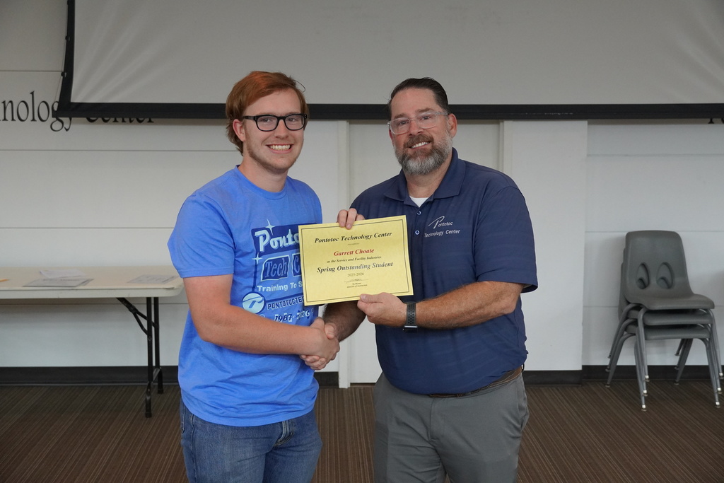 A student and Mr. Moore posing for a photo holding a certificate.