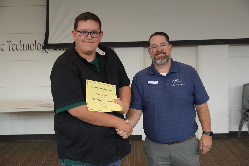 A student and Mr. Moore posing for a photo holding a certificate.