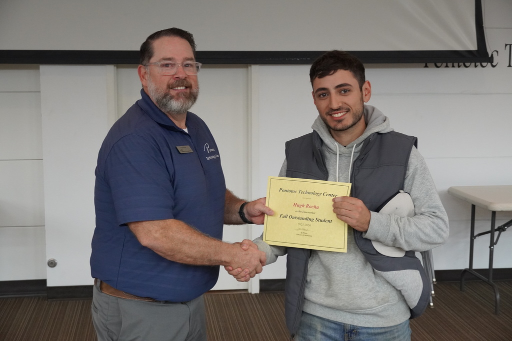 A student and Mr. Moore posing for a photo holding a certificate.