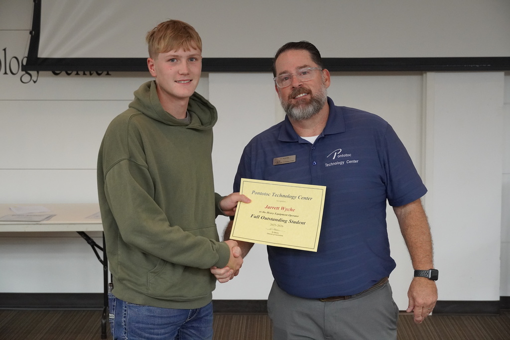 A student and Mr. Moore posing for a photo holding a certificate.