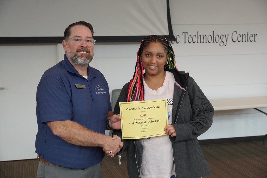 A student and Mr. Moore posing for a photo holding a certificate.