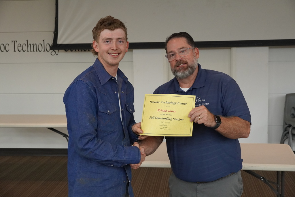 A student and Mr. Moore posing for a photo holding a certificate.
