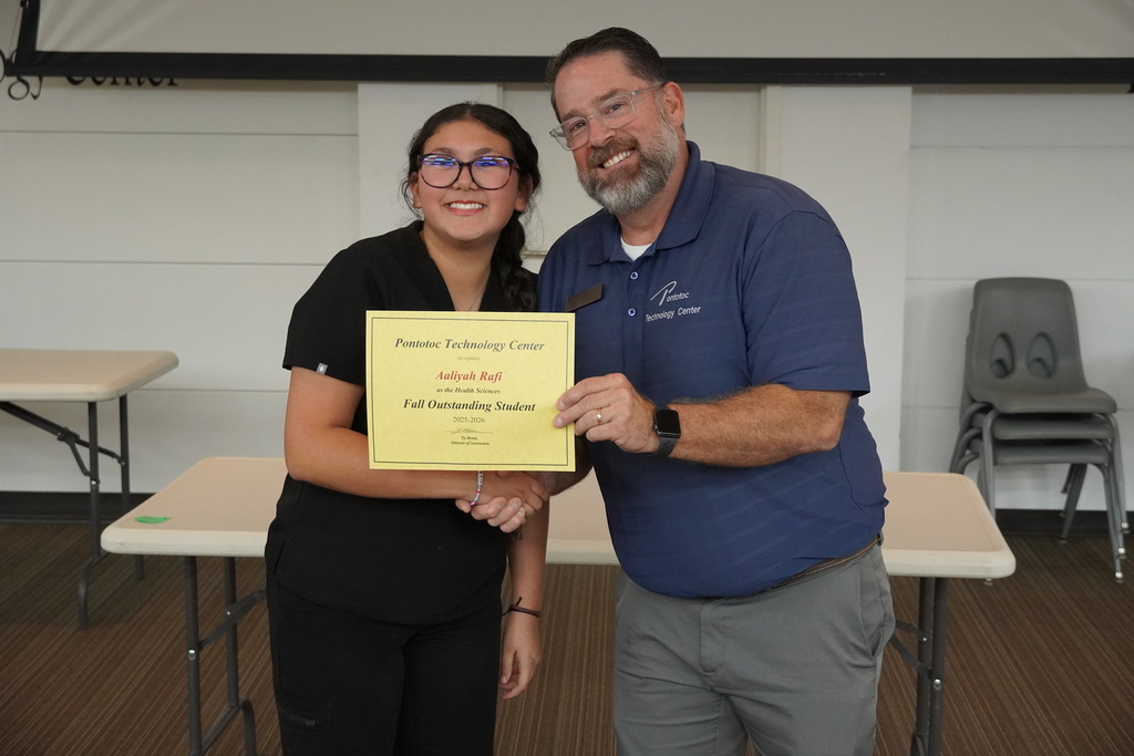 A student and Mr. Moore posing for a photo holding a certificate.