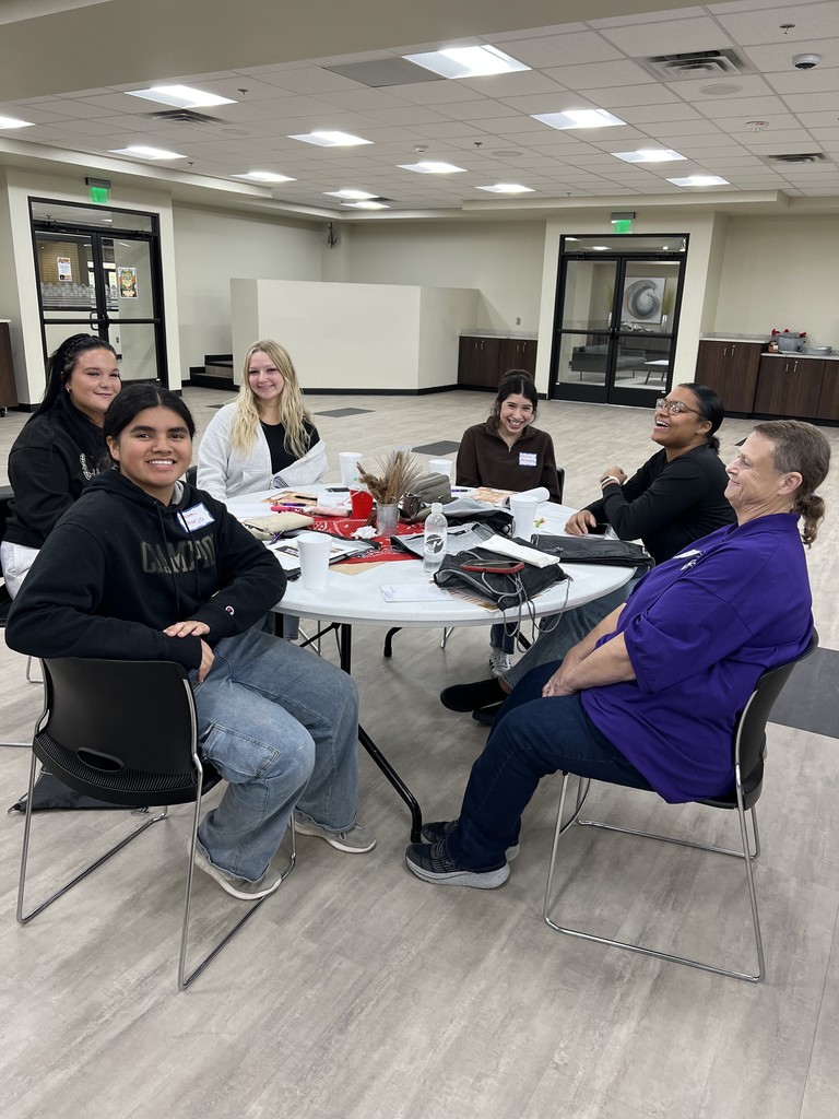 People sitting around a round table and chairs