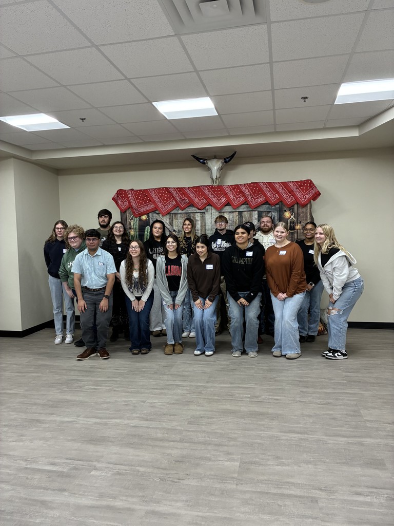Group of students posed against a western themed backdrop