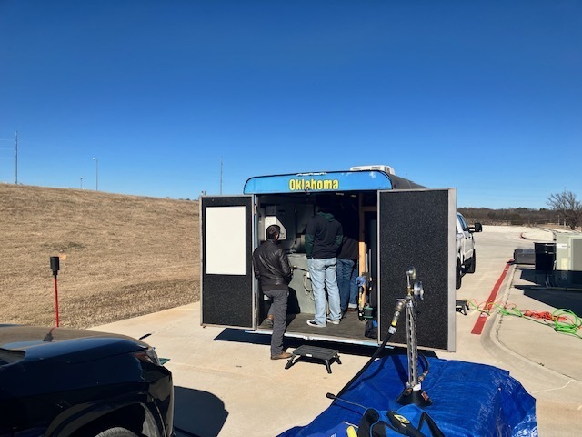The back of a trailer with the doors open and people standing inside
