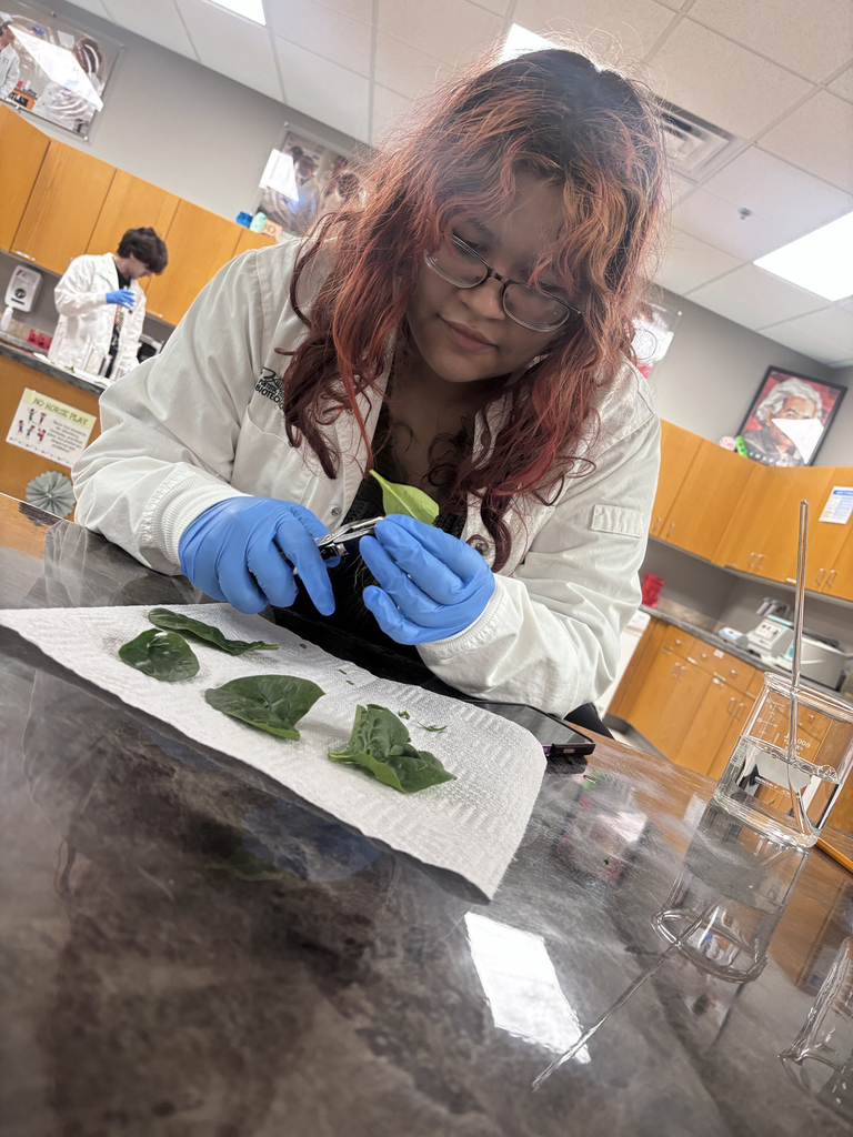 Student in white lab coat preparing a biotech experiment
