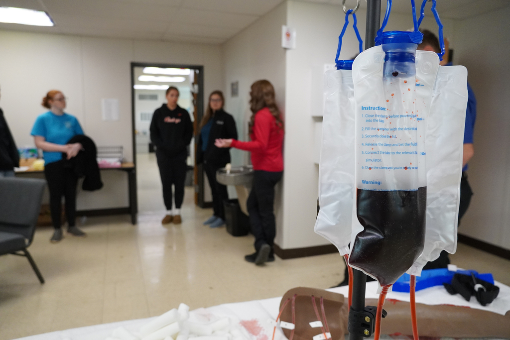 IV bag hanging in the foreground with people talking in the background