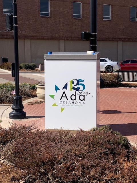 Image of large silver electrical box on a corner with a graphic wrap applied to it.