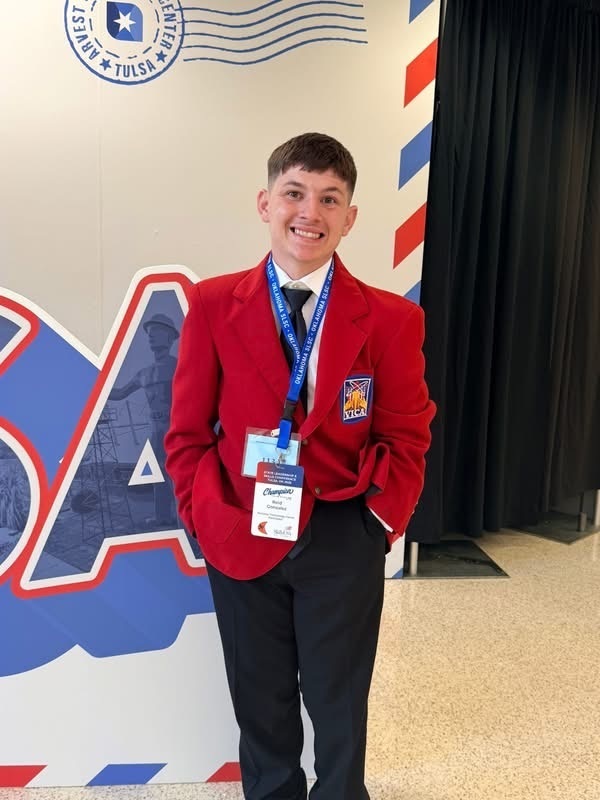 Photo of a student posing for a picture wearing a red jacket.