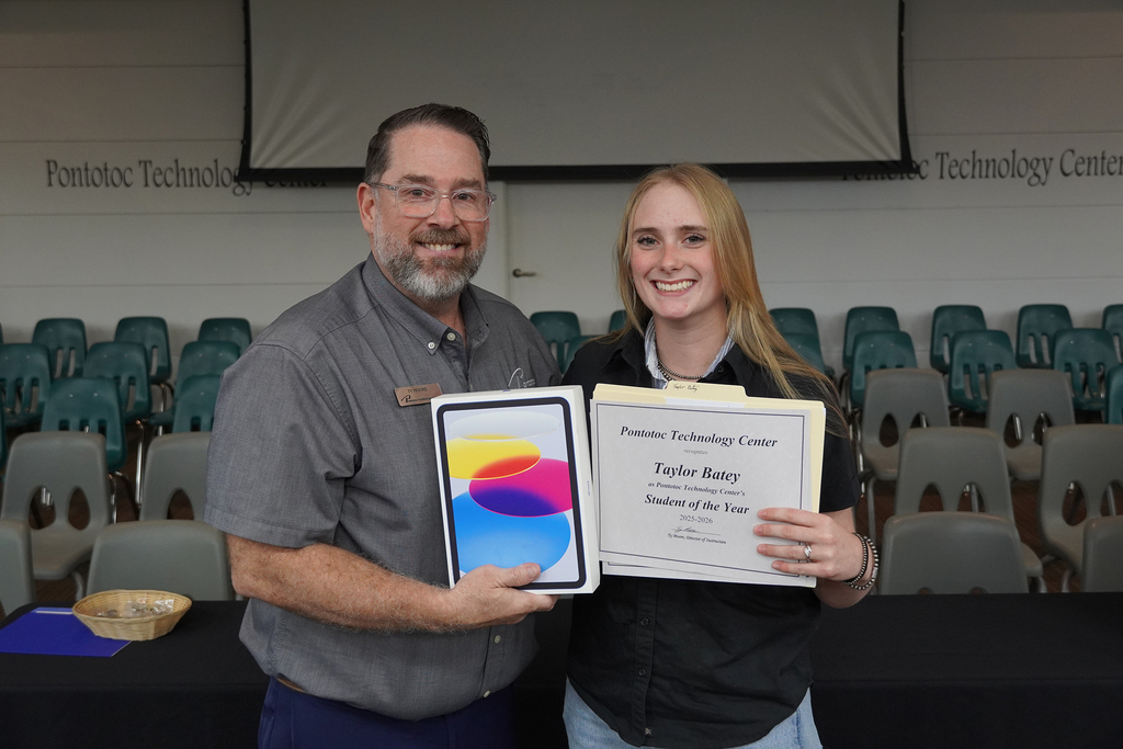 Two people posing with a certificate and a tablet device in a box.