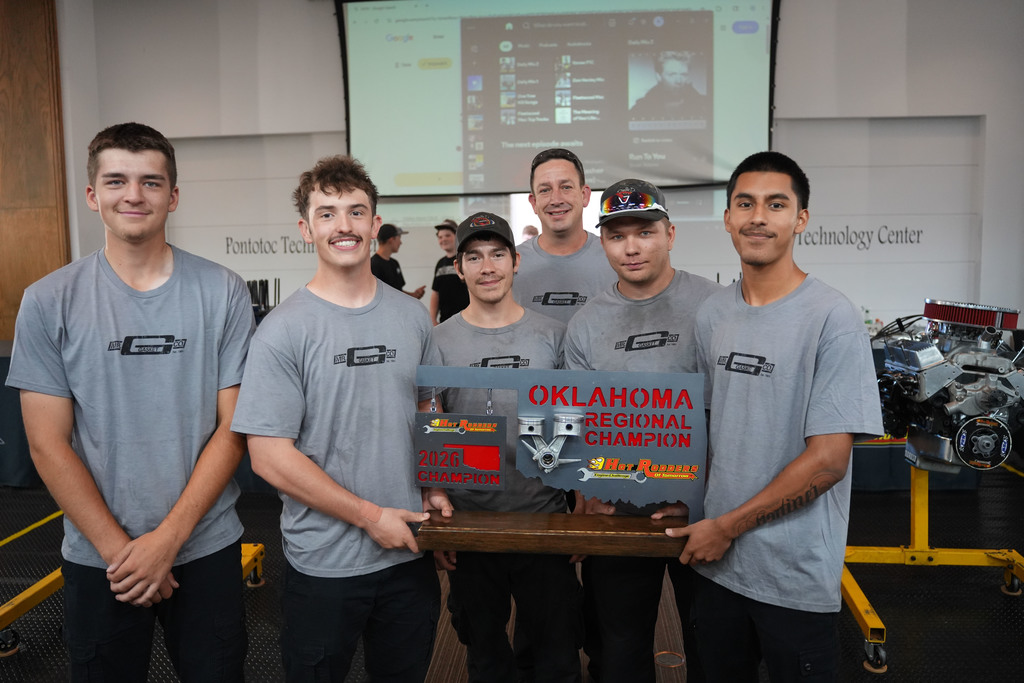 People standing next to each other holding a trophy