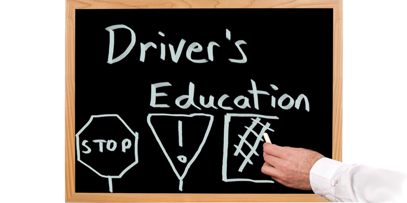Chalkboard with the words drivers education and street signs drawn on it