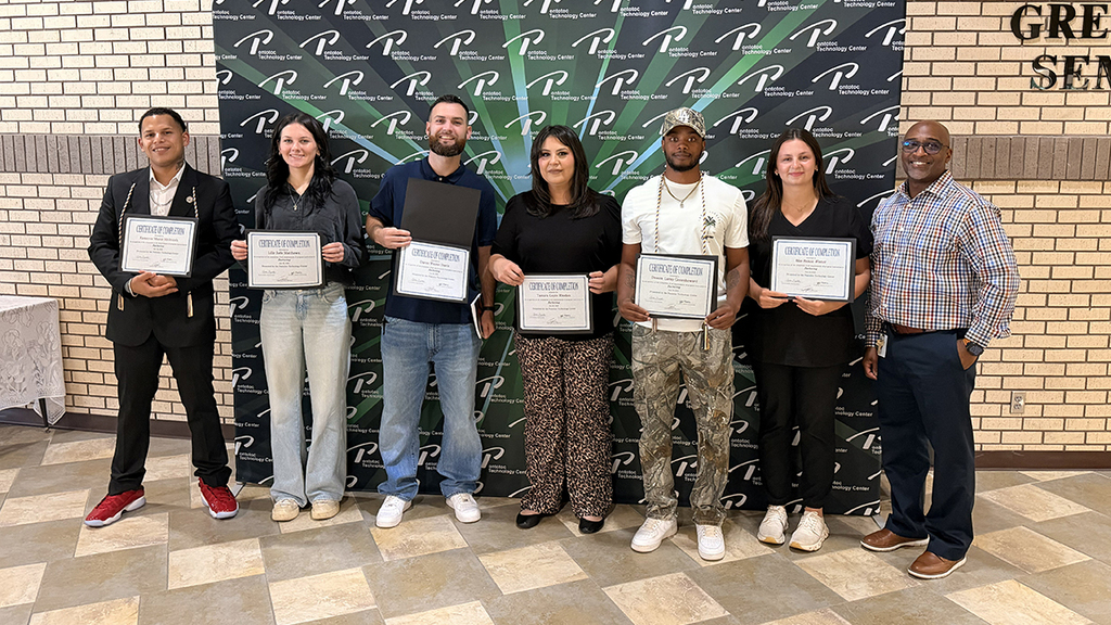 Group shot of students standing together holding certificates