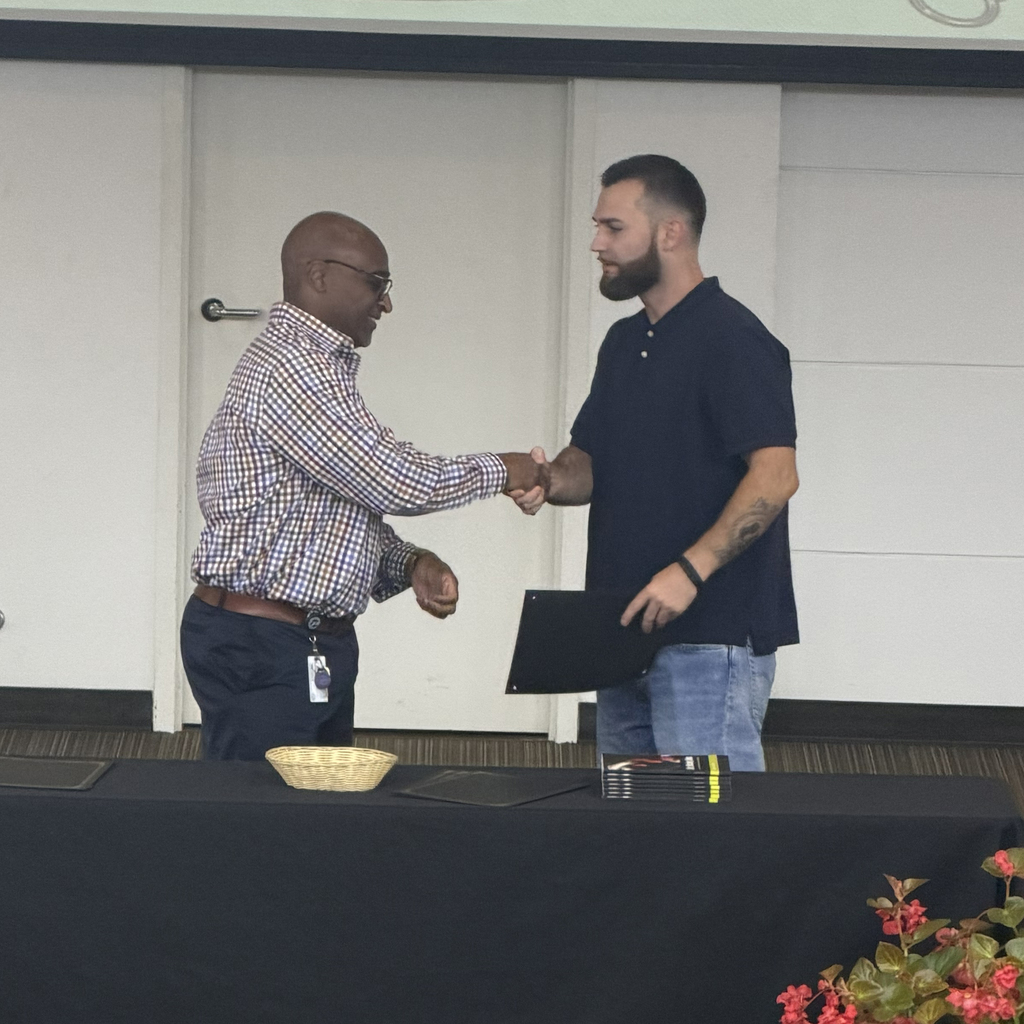 Man shaking hand with student holding certificate.