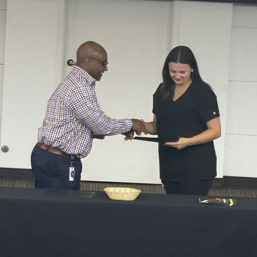 Man shaking hand with student holding certificate.